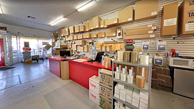 Interior view of a packing and shipping store with boxes, tape, and shipping supplies on display.
